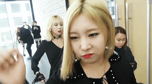 a woman with blonde hair and red lips is making a face