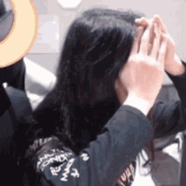a person is covering their face with their hands .