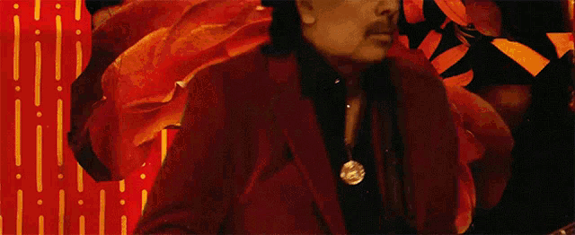 a man in a red suit and hat is standing in front of a colorful background
