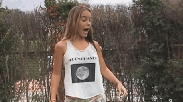 a girl wearing a white tank top that says moonchaser