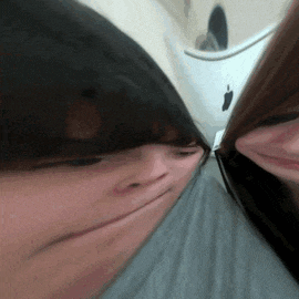 a blurry picture of two people 's faces with an apple logo in the corner