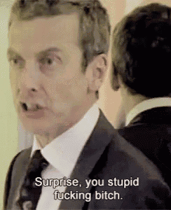 a man in a suit and tie is making a funny face and saying `` surprise , you stupid fucking bitch . ''