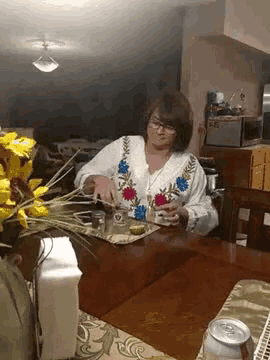 a woman is sitting at a table with a can of beer on the table