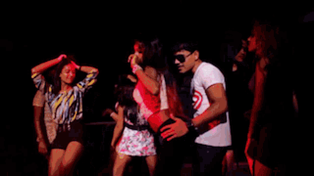 a man in a captain america shirt is dancing with a group of women