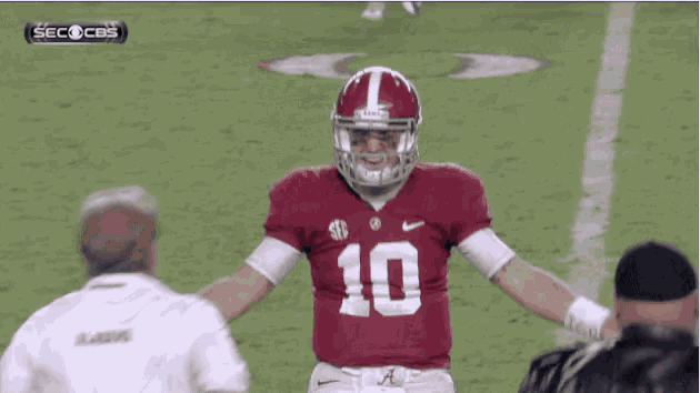 a football player with the number 10 on his jersey stands on the field