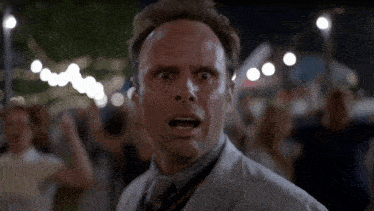 a man with a surprised look on his face is standing in front of a crowd