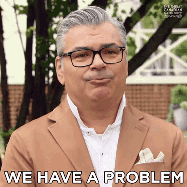 a man wearing glasses and a brown jacket says we have a problem