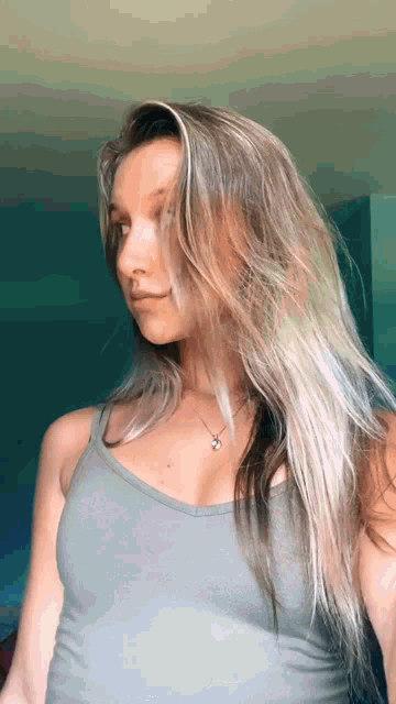 the woman is wearing a tank top and a necklace