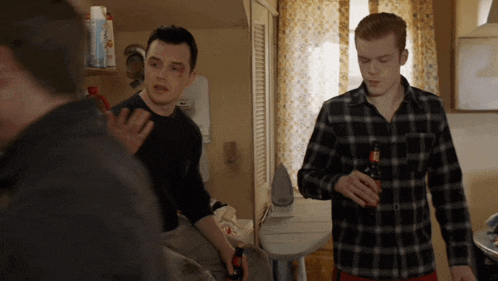 a man in a plaid shirt is holding a bottle