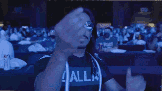 a man wearing sunglasses says let 's go baby in a crowded room