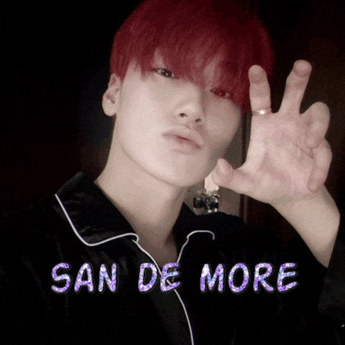 a young man with red hair is wearing a black shirt with the words san de more on the bottom