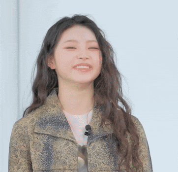 a woman wearing a snakeskin jacket is smiling