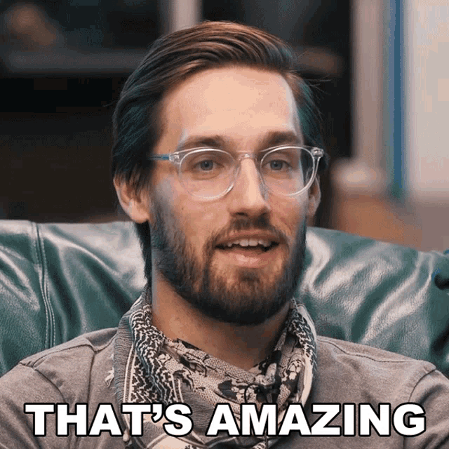 a man wearing glasses and a scarf says " that 's amazing "