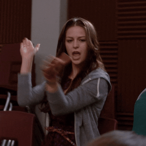 a woman sitting in a chair with her hands outstretched