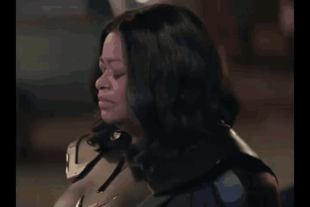 a woman in a superhero costume is looking down with her eyes closed