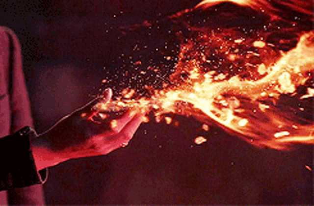 a close up of a person 's hand holding a fireball .