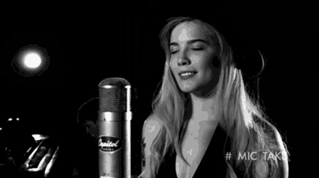 a woman in a hat is singing into a microphone ..
