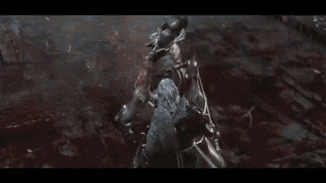 a man and a skeleton are fighting each other with swords in a dark room .