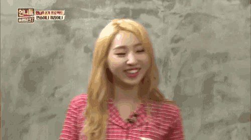 a woman in a pink plaid shirt is making a funny face