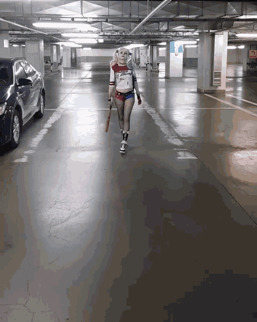 a woman in a harley quinn costume is walking down a parking garage