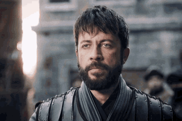 a man with a beard is wearing a leather armor