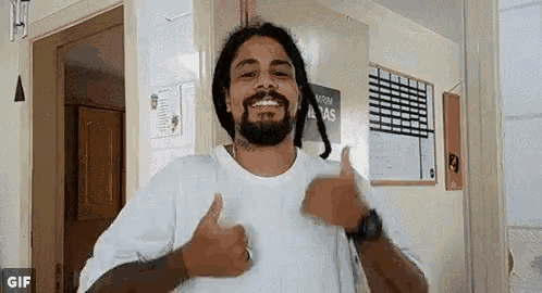 a man with dreadlocks is giving two thumbs up .