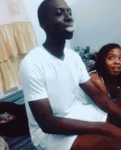 a man in a white shirt is sitting on a bed with a woman