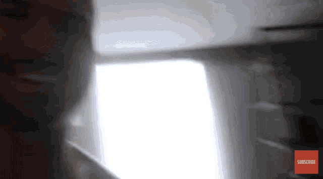 a blurred image of a person with a subscribe button on the bottom right