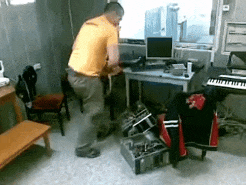 a man in a yellow shirt is standing in front of a keyboard