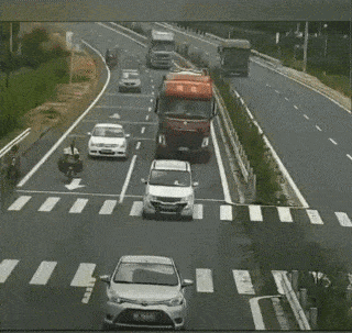 a red truck is driving down a highway with chinese writing on the side