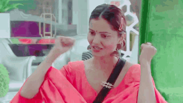 a woman in a red dress is making a funny face while holding her fist in the air .