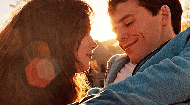 a man and a woman are looking into each other 's eyes and smiling .