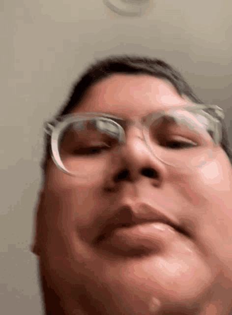 a close up of a person 's face with glasses on .