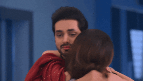 a woman wearing a bracelet hugging a man