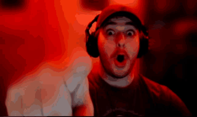 a man wearing headphones and a hat is making a surprised face