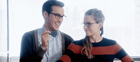 a man and a woman are standing next to each other and smiling .