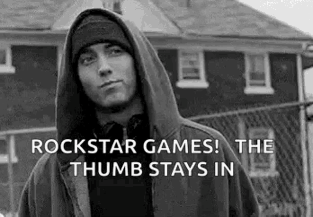 a black and white photo of eminem wearing a hoodie and a beanie .