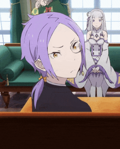 a girl with purple hair is sitting at a table with another girl