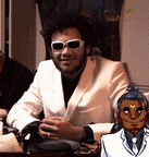 a man wearing sunglasses and a white jacket is sitting at a table