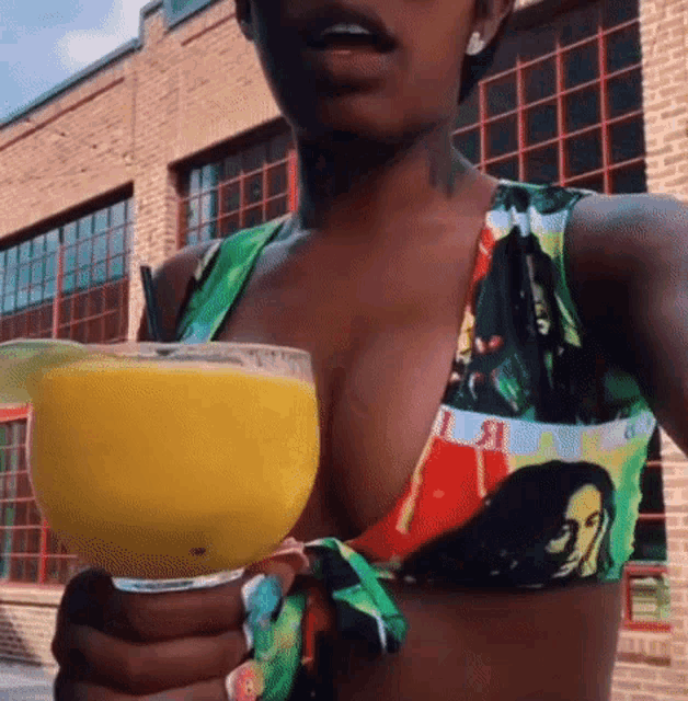 a woman in a bikini is holding a drink in her hand