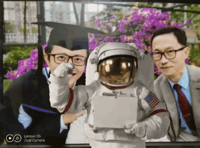 a picture of a man in a graduation cap and gown and a man in a suit and tie is taken by a dual camera