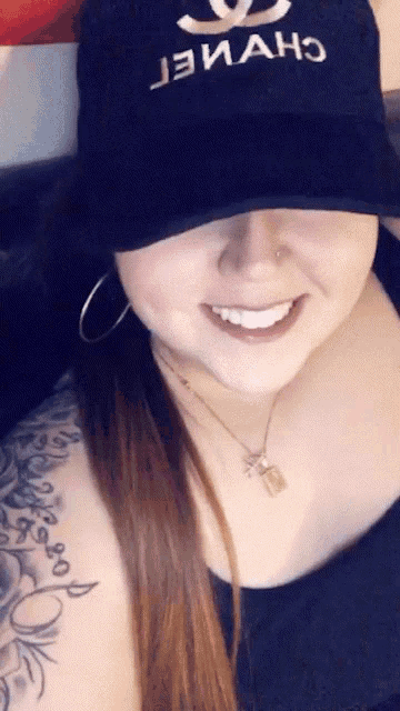 a woman wearing a black hat with chanel written on it