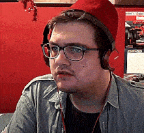 a man wearing glasses and headphones has a red hat on top of his head
