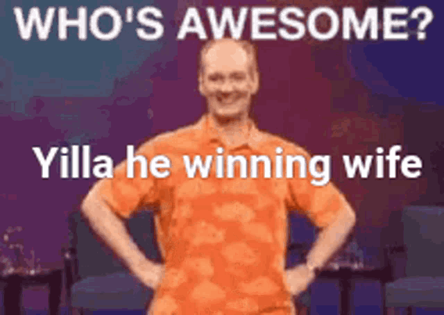 a man in an orange shirt is standing on a stage with his hands on his hips and a caption that says who 's awesome