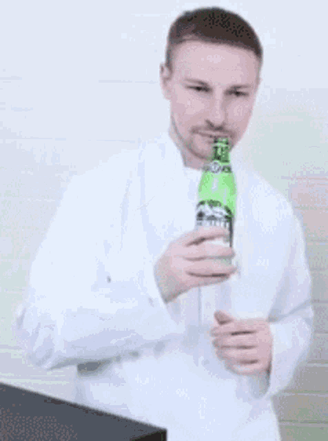 a man in a white coat is holding a green bottle