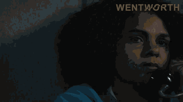 a woman talking on a phone with the word wentworth on the bottom right