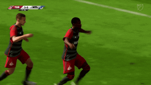 two soccer players are running on a field and the score is 3-0