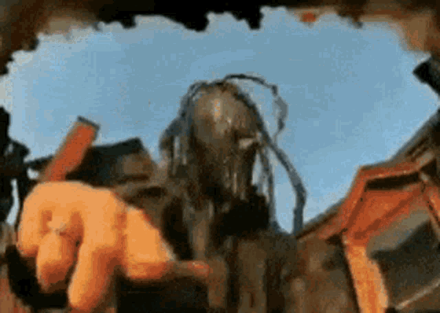 a statue of a man with dreadlocks is pointing at something in the sky
