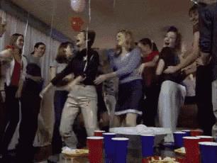 a group of people are dancing at a party with red cups on the table