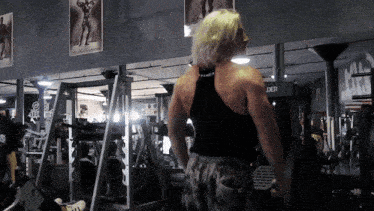 a man in a black tank top stands in front of a machine that says der